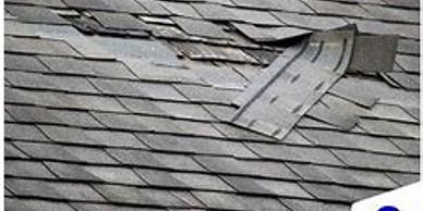 Damaged roof with visible broken and missing shingles.