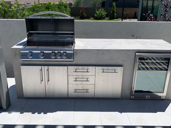 Modern outdoor concrete kitchen with grill.