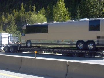 large tow truck hauls large motor home down the highway