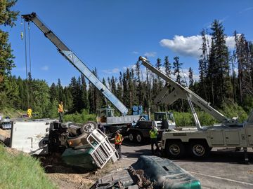 Large tow truck and crane assist overturned semi