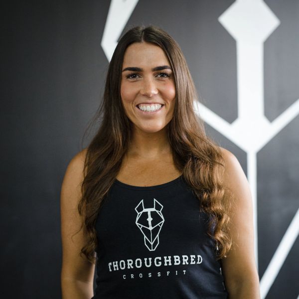 Smiling woman in a Thoroughbred CrossFit tank top.