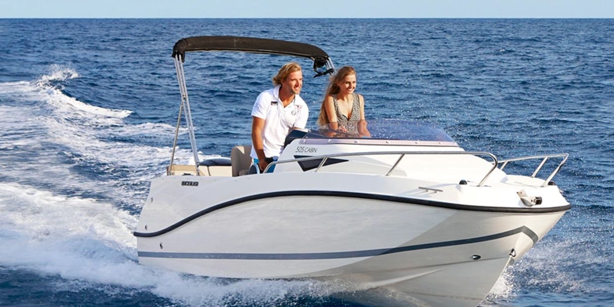 A couple enjoying a boat ride on clear blue ocean waters.