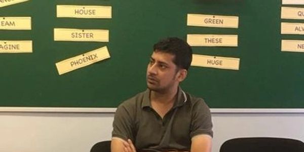 A student sitting at a desk with his arms folded