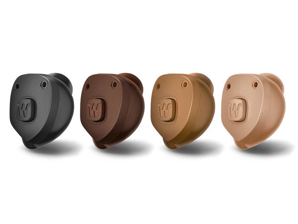 Four small hearing aids in different skin tones, designed for discreet use.