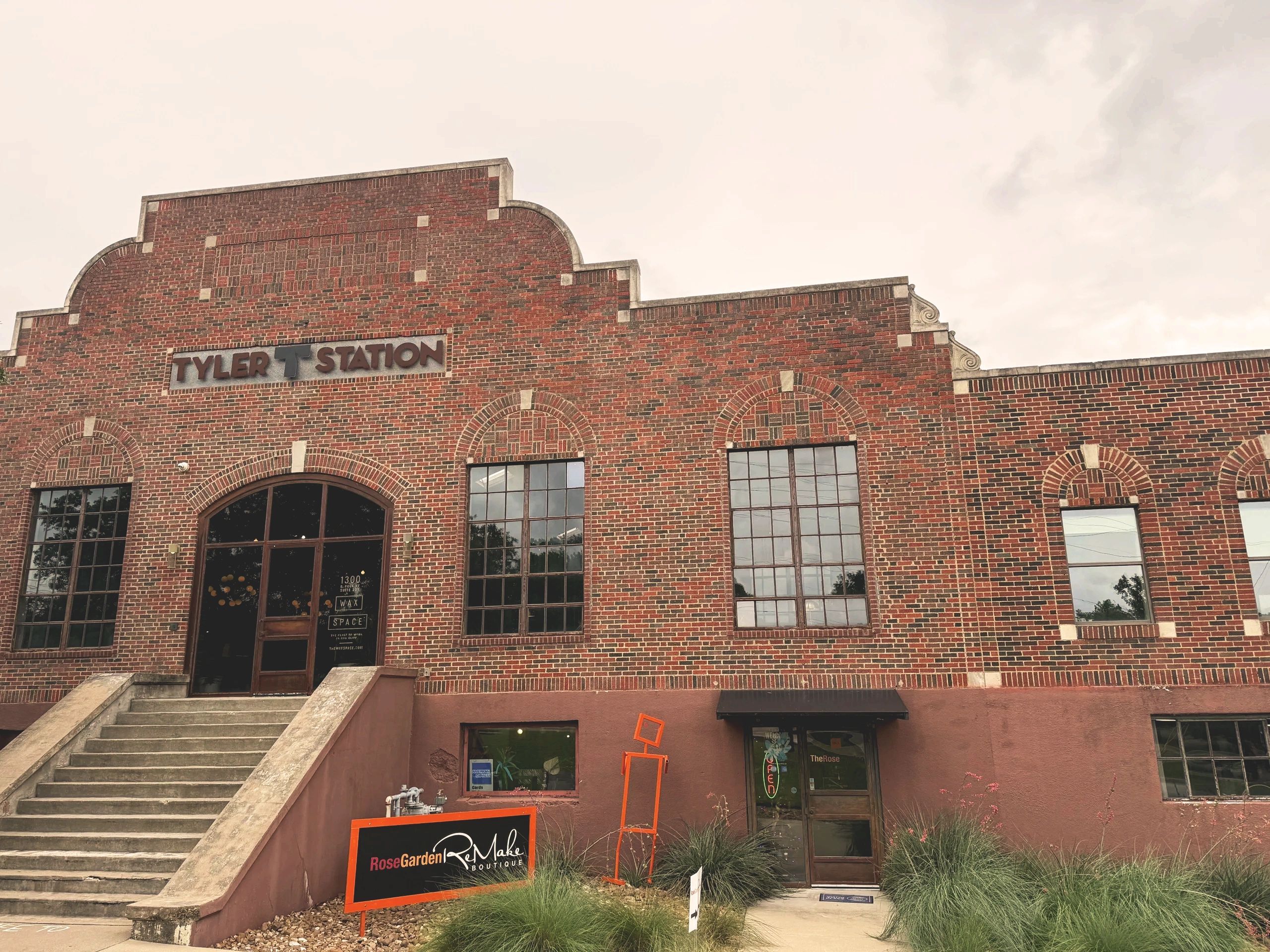 Brick building labeled Tyler Station with boutique signage outside.