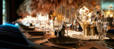 Elegant dining table set with glassware and soft lighting.