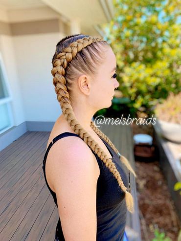 Woman with long, thick braided hairstyle outdoors.