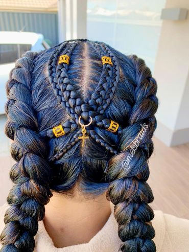 Intricate braided hairstyle with gold accents and cross charm.