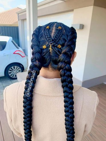 Intricate double braided hairstyle with gold accessories and cross charm.