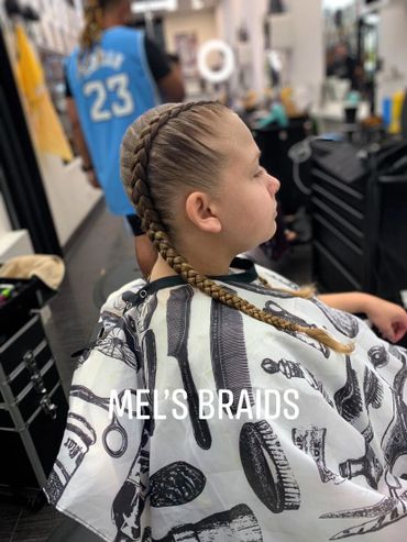 Young girl with neat braids sitting in a salon chair.