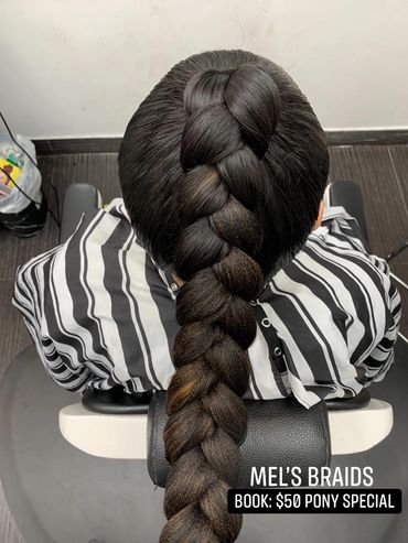 Intricate thick braid styled on dark hair with striped shirt.