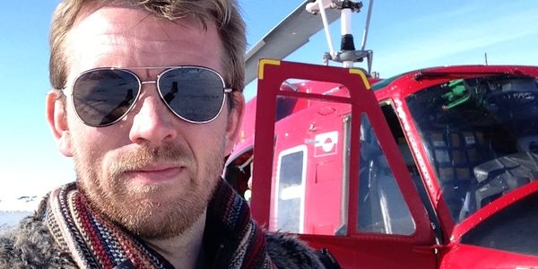 Hjortur Smarason in front of an Air Greenland Bell 212 helicopter in Greenland.