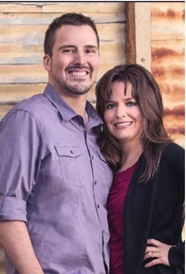 John and Dawna Thomas standing closely together looking into the camera smiling. 