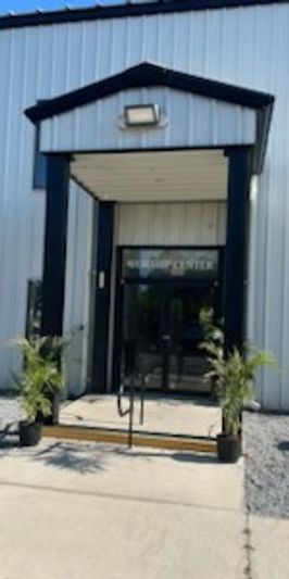 Entrance to a building labeled 'Visitor Center' with potted plants on either side.