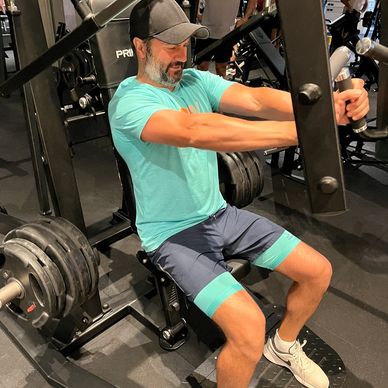 Man exercising on a chest press machine at the gym.
