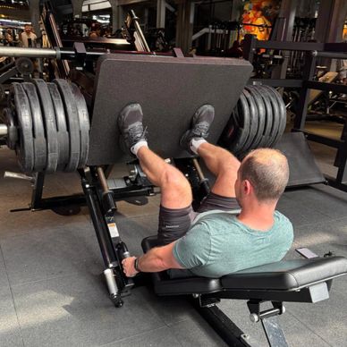 Man doing leg press with heavy weights at the gym.