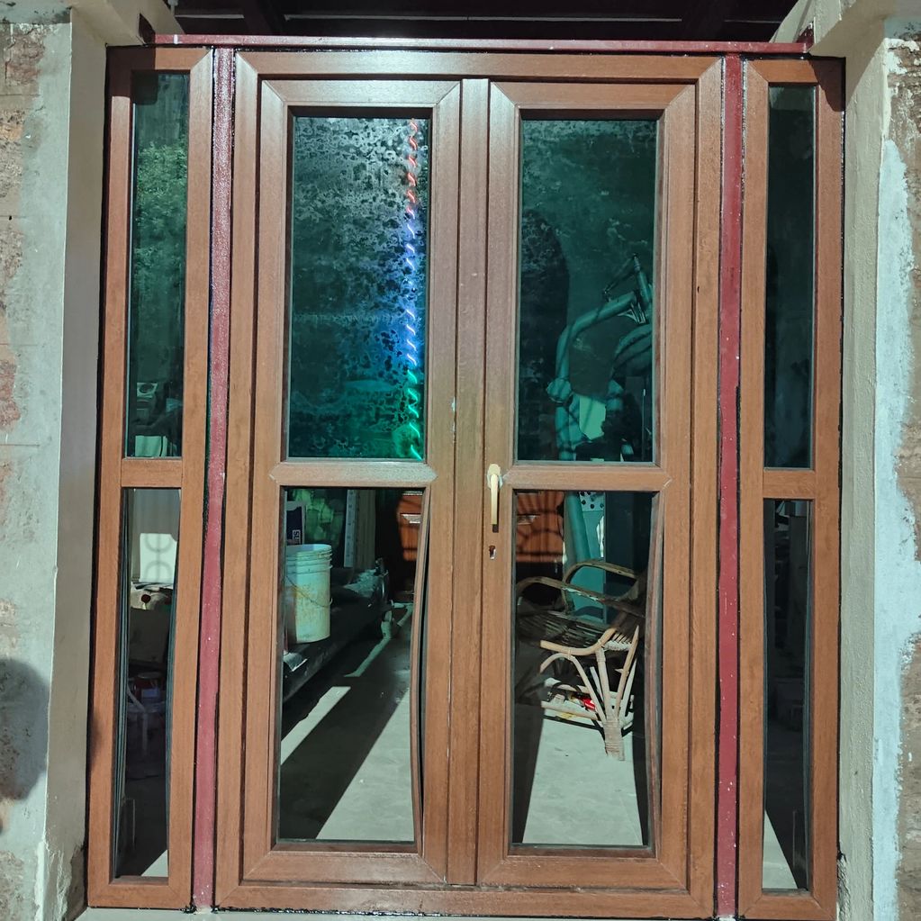 Wooden framed glass door with reflective panels and a decorative arch above.