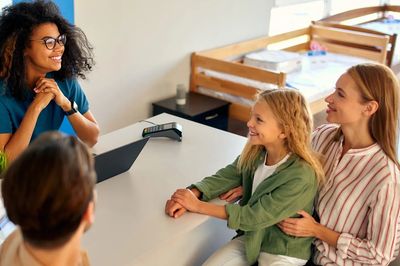 A woman consulting with a family in an office setting.