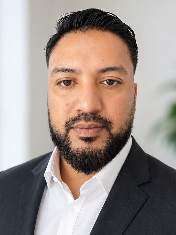 Portrait of a man in a suit and white shirt.