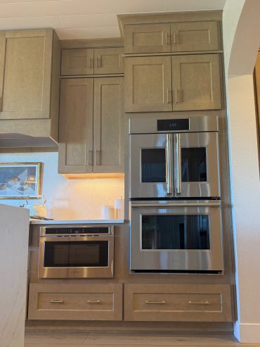 Modern kitchen with stainless steel appliances and wood cabinetry.