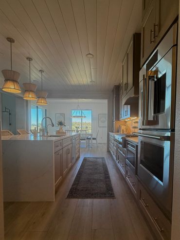 Modern kitchen with island and dining area in the background.
