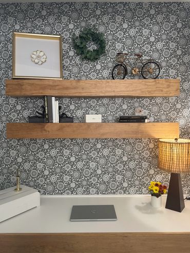 Minimalist workspace with wooden shelves and decorative items.