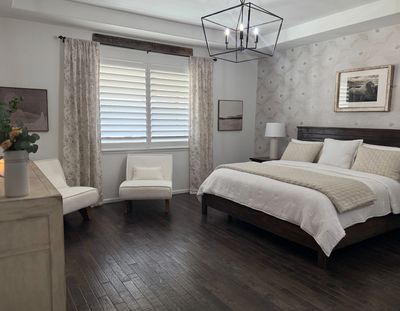 Cozy bedroom with wooden floor and neutral decor.
