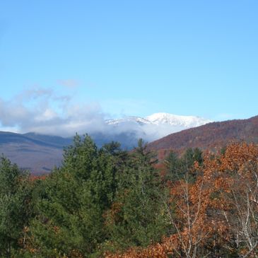 Fall View from the Grand Victorian of the forest, mountains and snow capped Mt Washington .