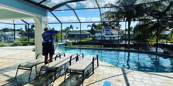 team member power washing a pool deck