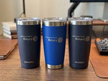 Three Rotary travel mugs on a desk.