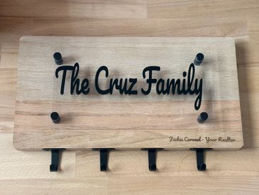 Wooden key holder with "The Cruz Family" text and four hooks.