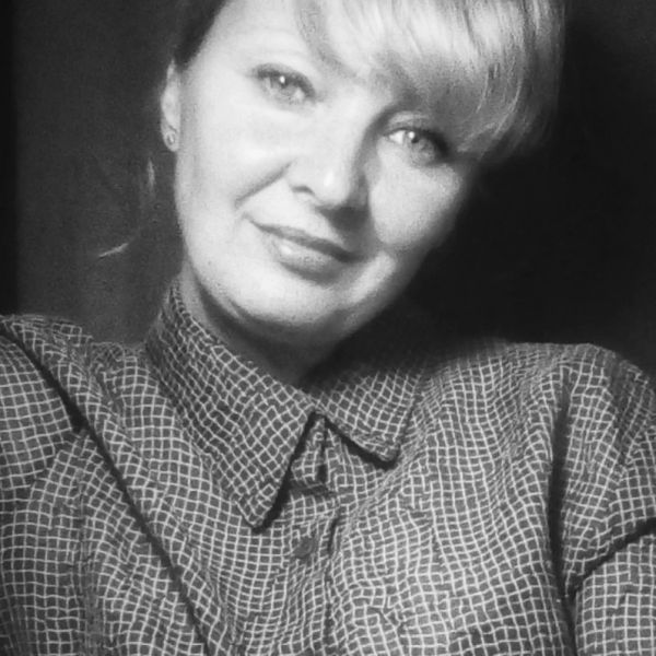 Black and white portrait of a woman smiling gently at the camera.