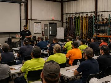 A group of workers attentively listening to a trainer in a workshop.