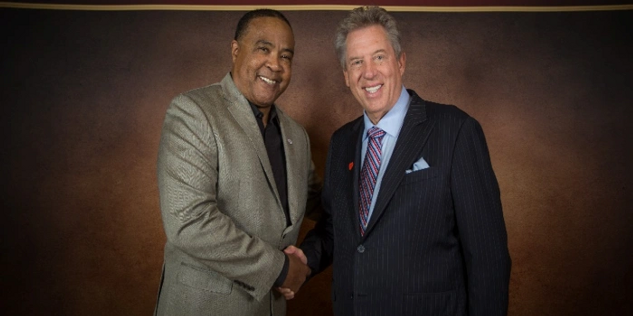 two men posing and shaking hands