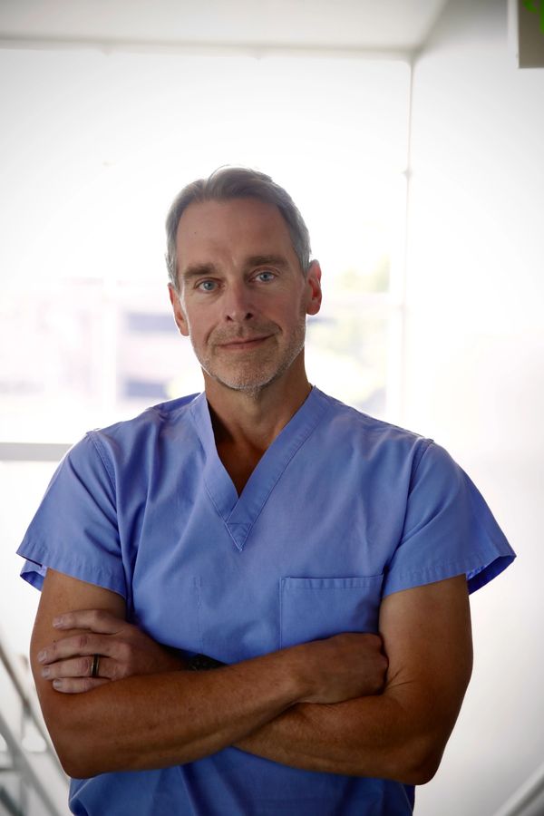 Derron Wilson, MD, FIPP Interventional Pain Management physician and expert witness in scrubs