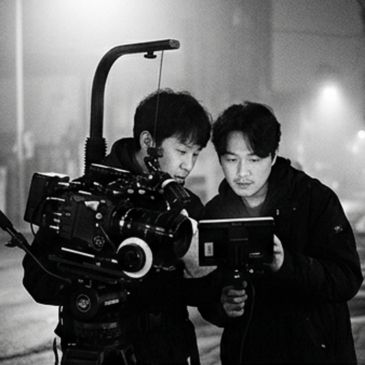 Two men operating a professional camera on set.
