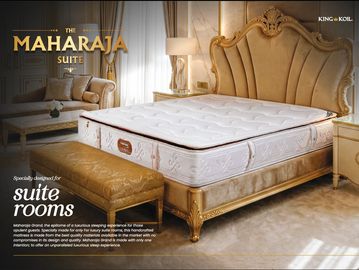 Luxurious Maharaja Suite bed with elegant gold accents and plush mattress.