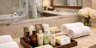 Luxury bathroom amenities and towels neatly arranged on a marble counter.