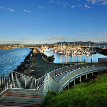 A marina filled with sailboats under a bright blue sky.