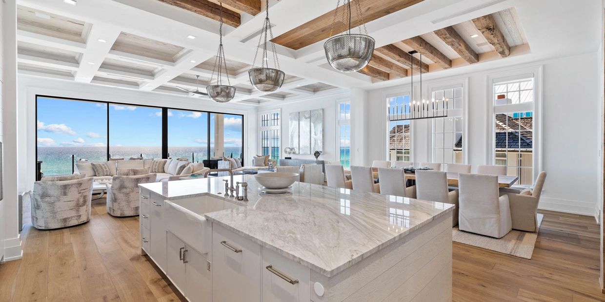 Bright coastal living space with wooden beams and ocean view.