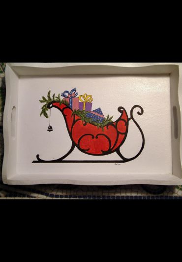A painted wooden tray featuring a red sleigh with Christmas gifts and greenery.