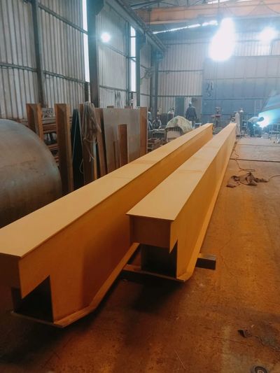Large metal beams inside an industrial workshop.