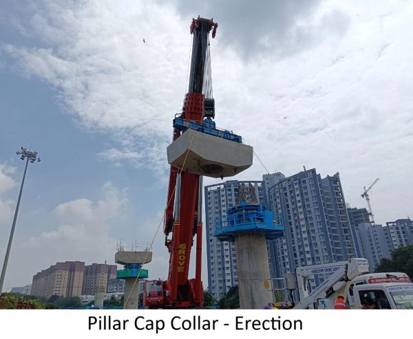 Crane lifting a pillar cap collar at a construction site.