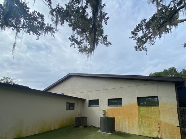 Side view of a building with stained walls and air conditioning units.