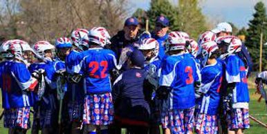Photo of a youth lacrosse team huddled and talking with two coaches