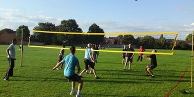 Photo of people in a park playing volleyball