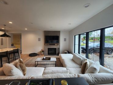 Modern living room with white sectional sofa and large windows.