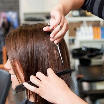 Persona cortándose el cabello en una peluquería.