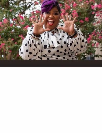 Happy woman with purple hair and polka dot shirt showing ten fingers.
