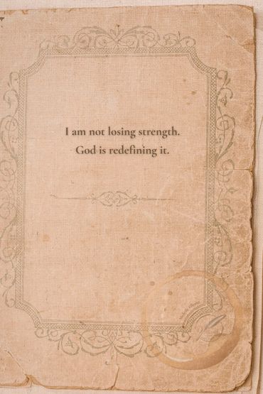 Old vintage journal book, with a quote saying; “I am not losing strength, God is redefining it.”